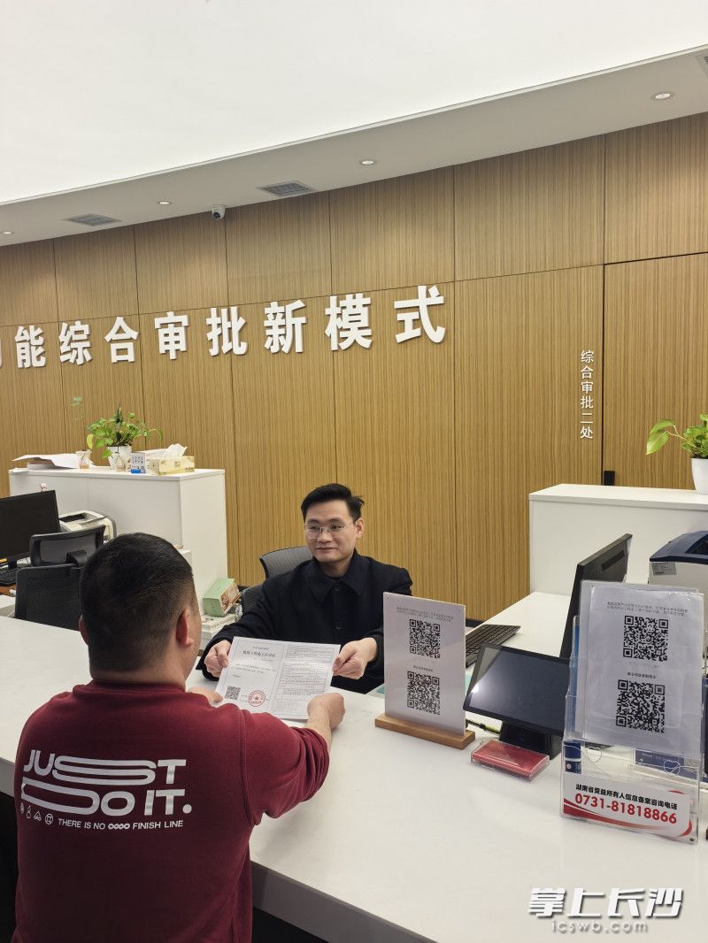 1月15日晚，长沙经开区行政审批服务局工作人员将工程规划许可证等证件交给企业项目负责人。