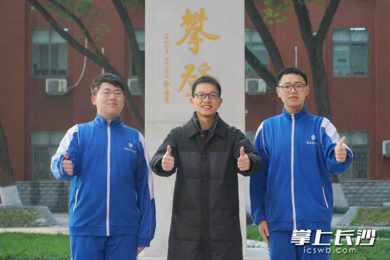 入选生物奥赛国家队的王梓衡（左）、刘隆瑞（右）在湖南师大附中攀登碑前，与主教练黄俊老师合影。 均为长沙晚报通讯员梁文婷摄