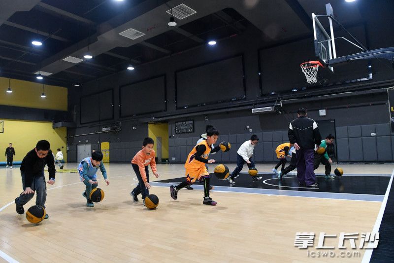 保利·中环广场五环时代全民健身中心内,小朋友们在练习打篮球。 保利·中环广场五环时代全民健身中心内,小朋友们在练习打篮球。
