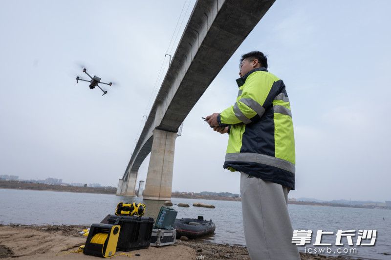 一架无人机正沿着新兴特大桥钢梁平稳飞行，全方位采集图像资料。