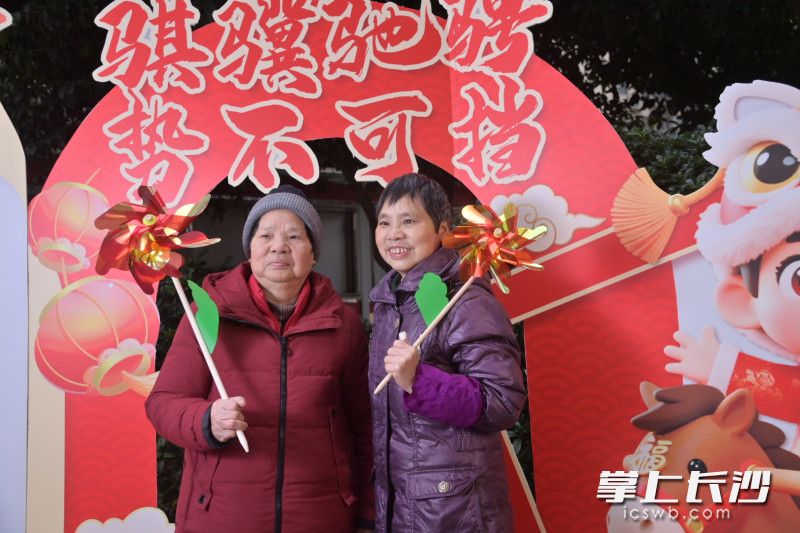 居民们纷纷来到精心布置的拍摄背景前留影。