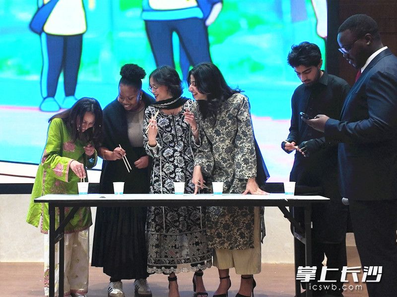 留学生参与筷子夹乒乓球趣味游戏。 留学生参与筷子夹乒乓球趣味游戏。