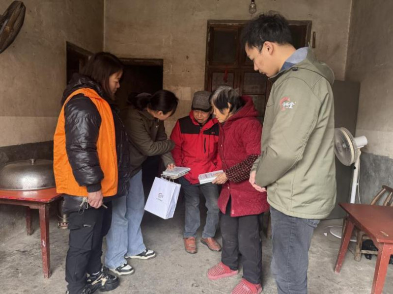 工作人员给邓建明送上针对关节疼痛的膏药。