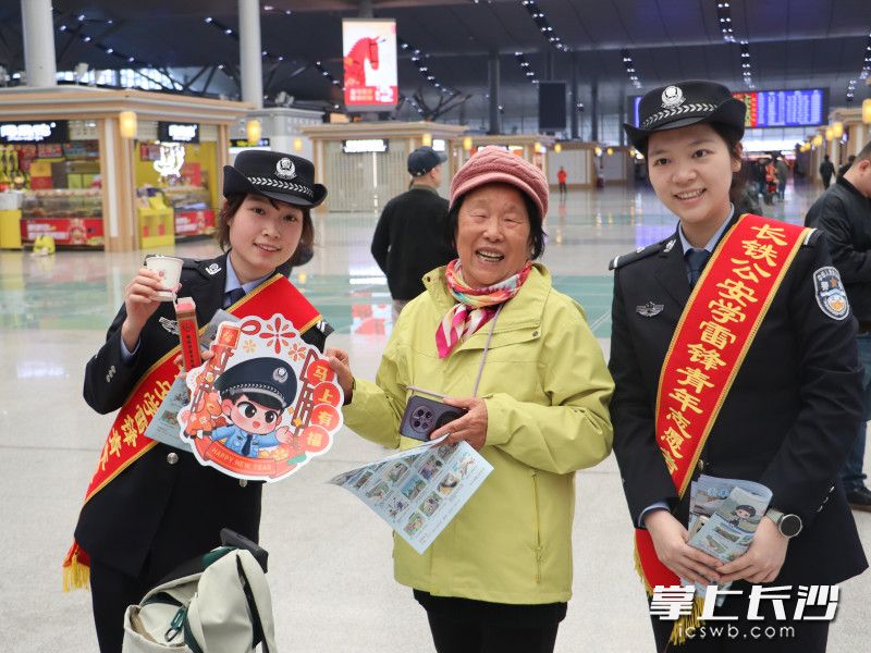 身披“学雷锋志愿服务队”红色绶带的青年民警们为旅客送上平安祝福。 均为长沙晚报全媒体记者张洋子摄