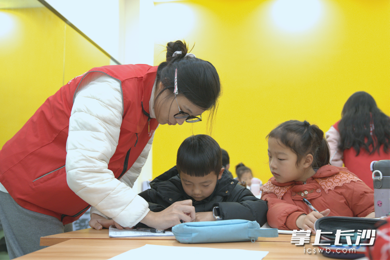 志愿者正专心辅导孩子。