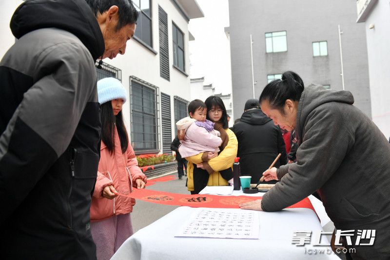 书法名家现场挥毫泼墨，写春联、福字，免费送给村民。