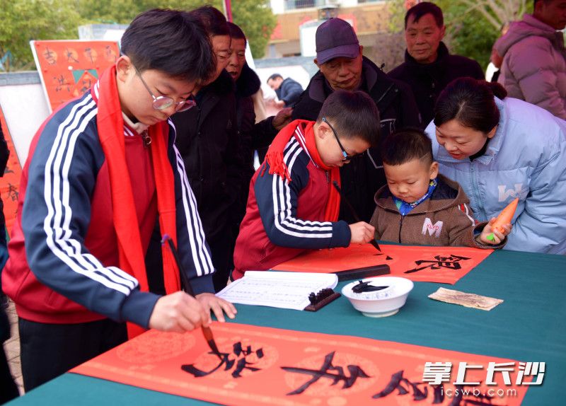 小小书法达人为群众写春联。 均为灰汤镇文联供图