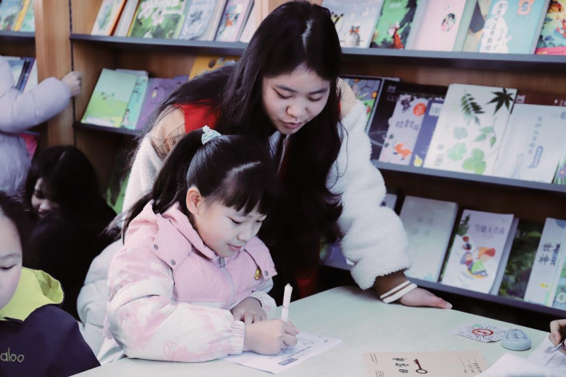 丰裕村依托农家书屋开展假期伴读辅导，返乡大学生耐心指导孩子完成作业。