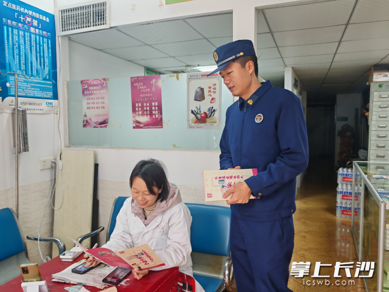 消防宣传员在向商户发放消防宣传资料。 长沙晚报通讯员 汤淑 摄