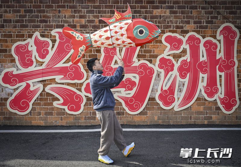 游客在兴马洲文化墙前打卡留念。