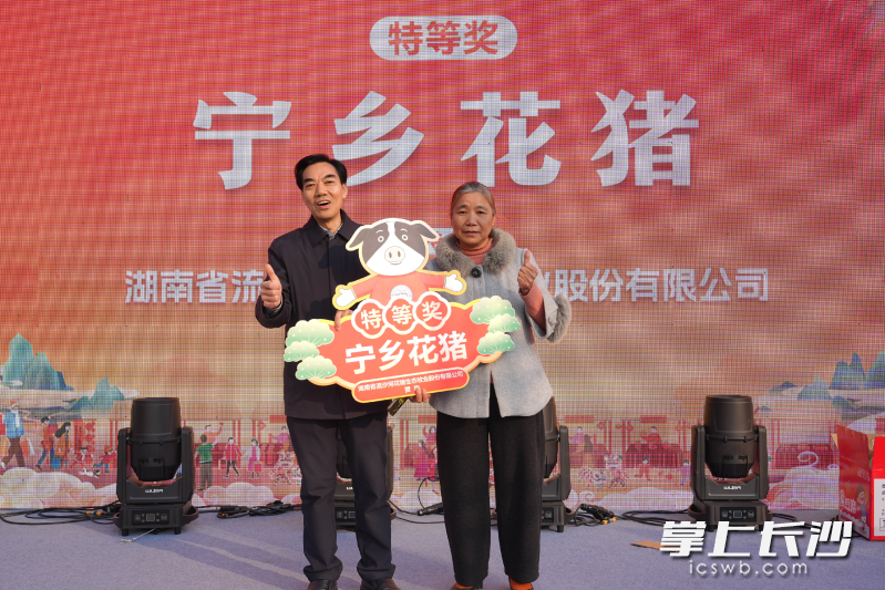 一位网名叫“乡里乡亲”的大姐（右）幸运获得特等奖——一整只宁乡花猪。