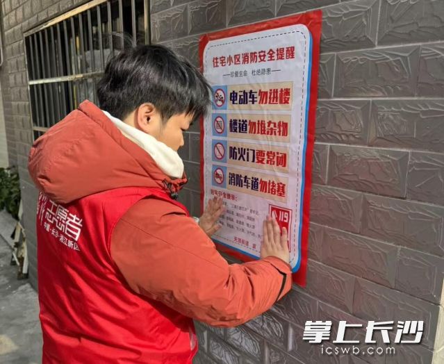 工作人员在重点场所张贴宣传海报。  均为长沙晚报通讯员向玲娅供图