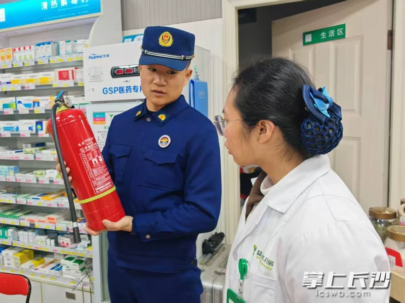 消防宣传员指导商户使用灭火器材。长沙晚报通讯员 刘鑫 摄