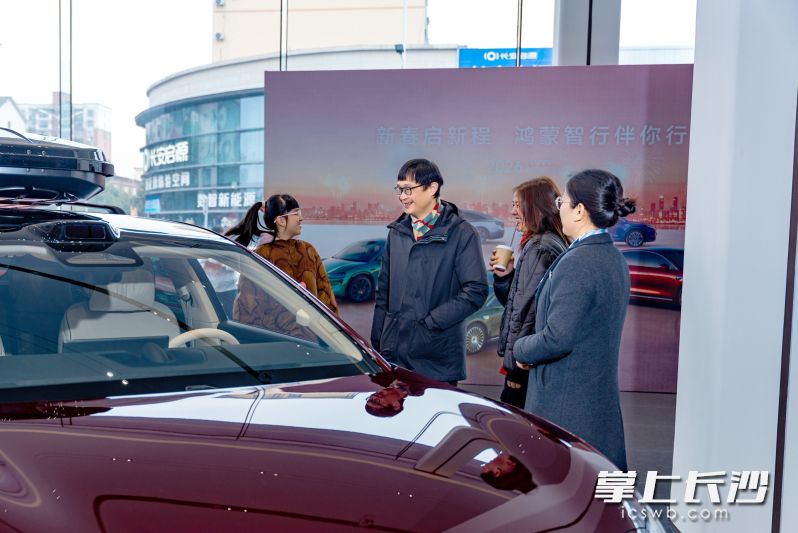 在4S店里，前来看车的一家三口被新款车型吸引。