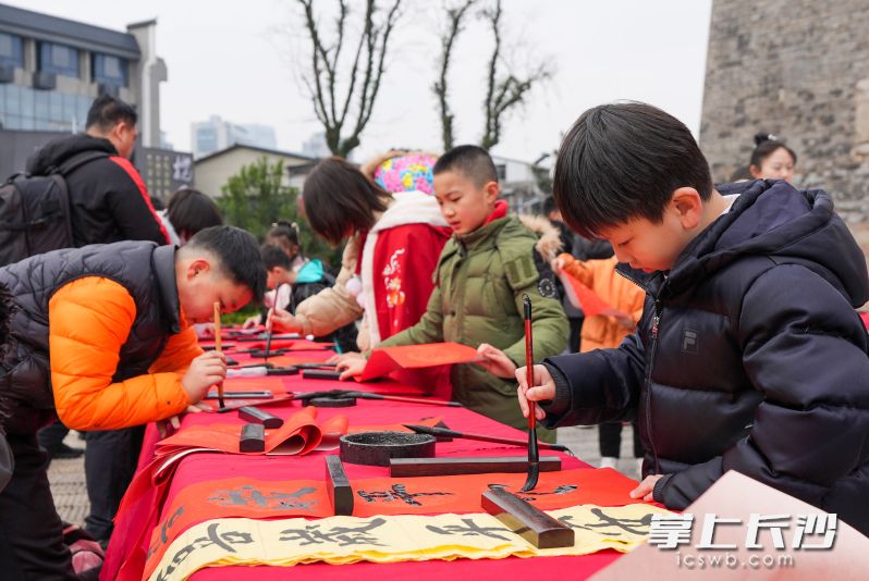 小朋友题写春联。