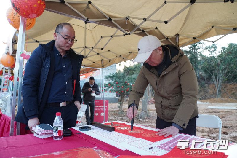 桥头铺村书法爱好者现场创作春联。