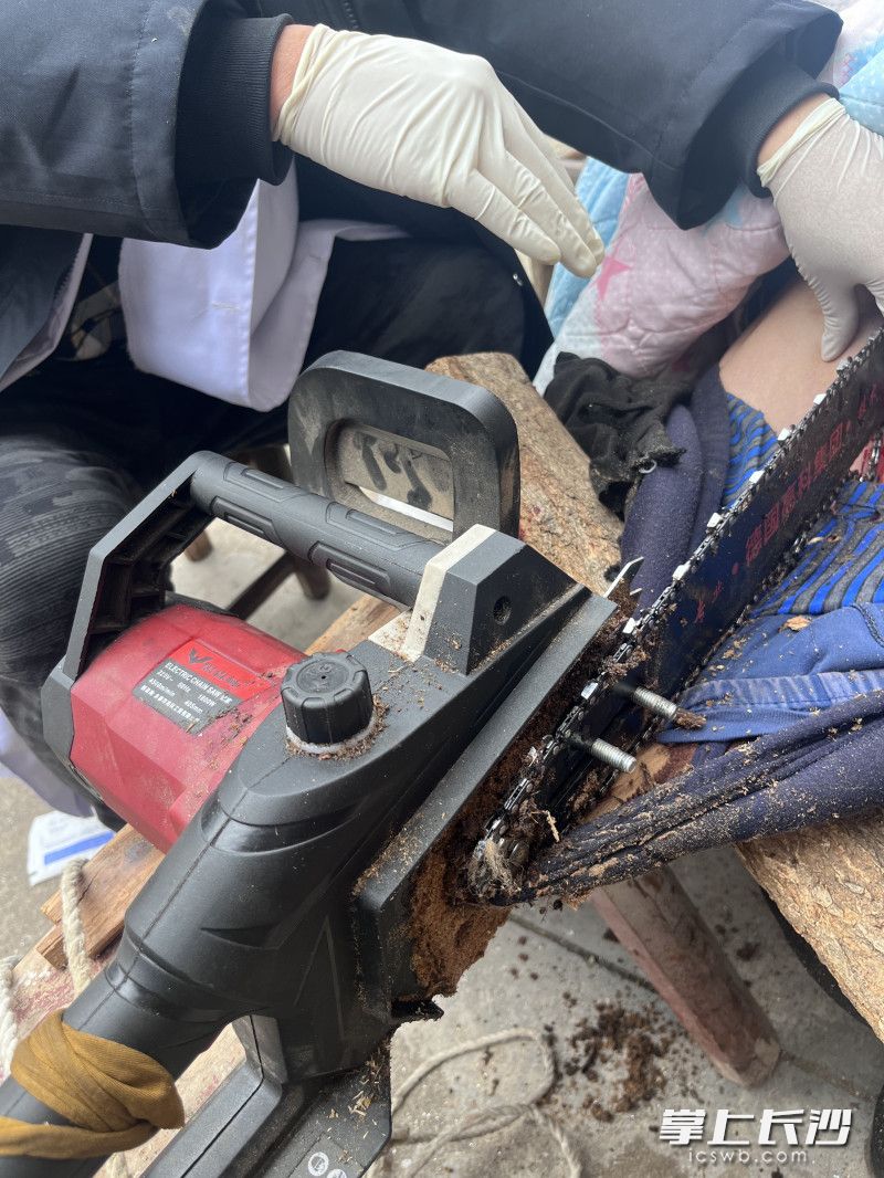 老人在锯木头时不慎锯到自己。  均为长沙晚报通讯员王磊摄