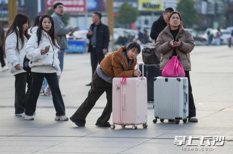 旅客们推着行李箱赶路。