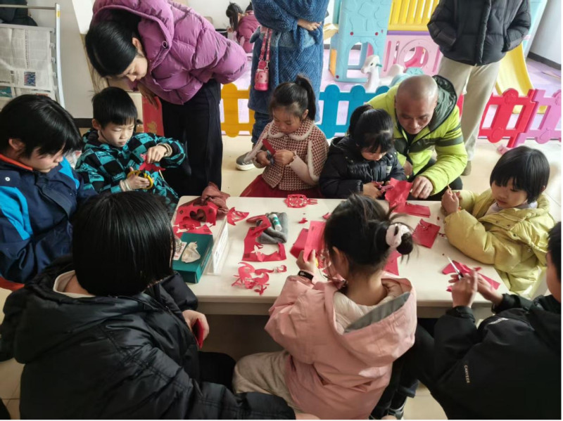 孩子们在书屋里围坐一桌,认真剪着手里的窗花。 孩子们在书屋里围坐一桌,认真剪着手里的窗花。