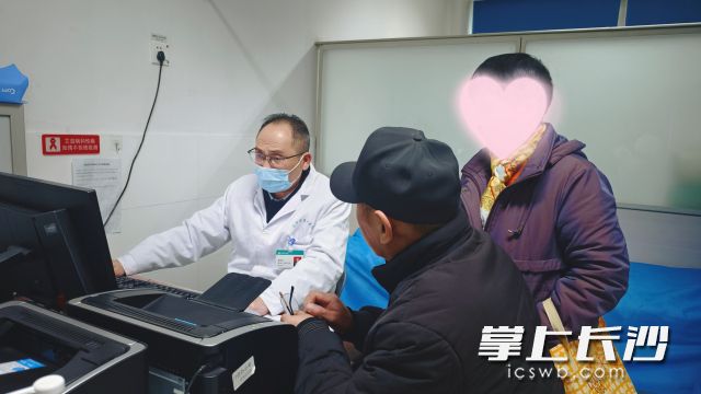 泌尿外科主任、主任医师唐智旺为前来就诊的患者细心问诊。