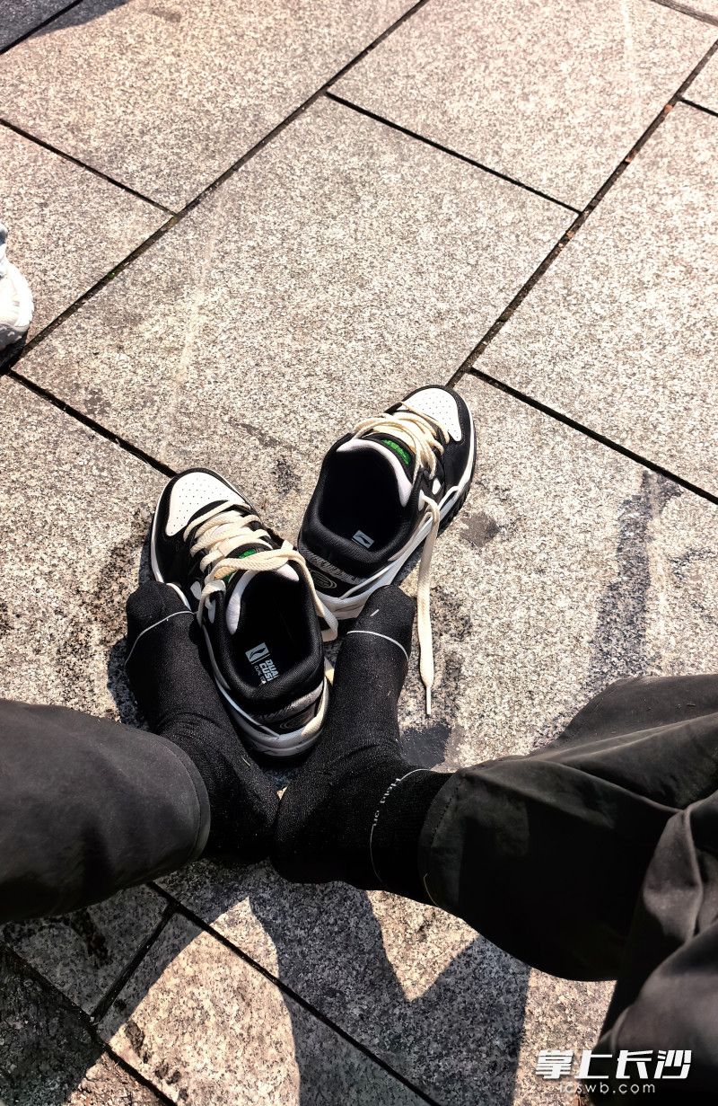 贾先生将小女孩救上岸后来到公园外晒鞋袜。