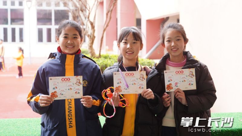 3名学生展示自己的“游园卡”。