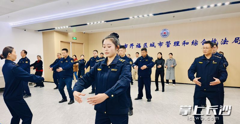 女同事当教练教学八段锦，男队员学得有板有眼。均为长沙晚报全媒体记者 李卓 摄