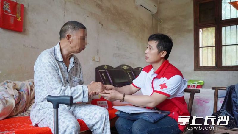 付春雷（右）在受助老人家中。受访者供图