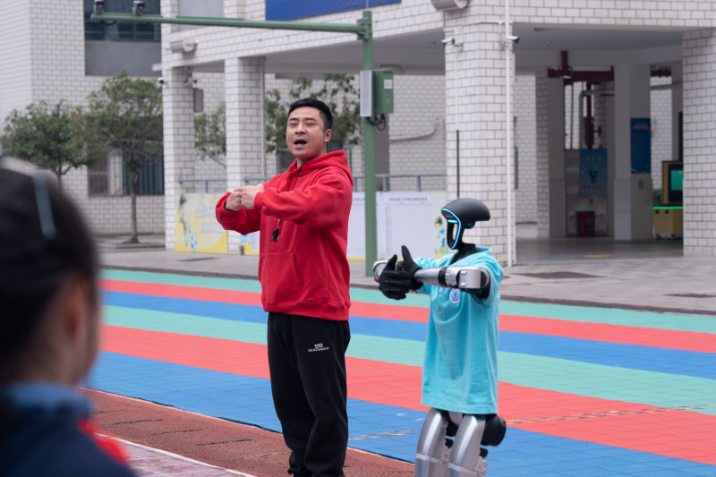 机器人“小清”和体育老师一起领操。