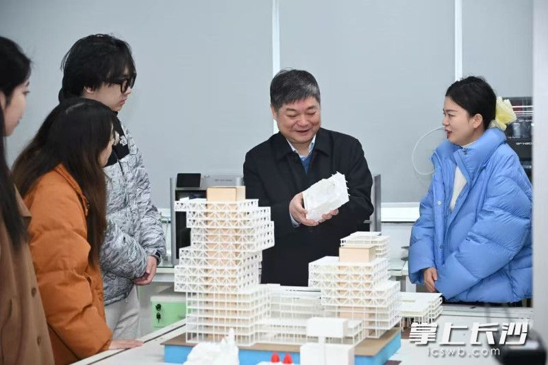 石磊（中）与学生一起交流。