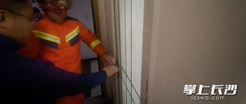 消防员正在破门营救。 长沙晚报通讯员 黄文平 摄