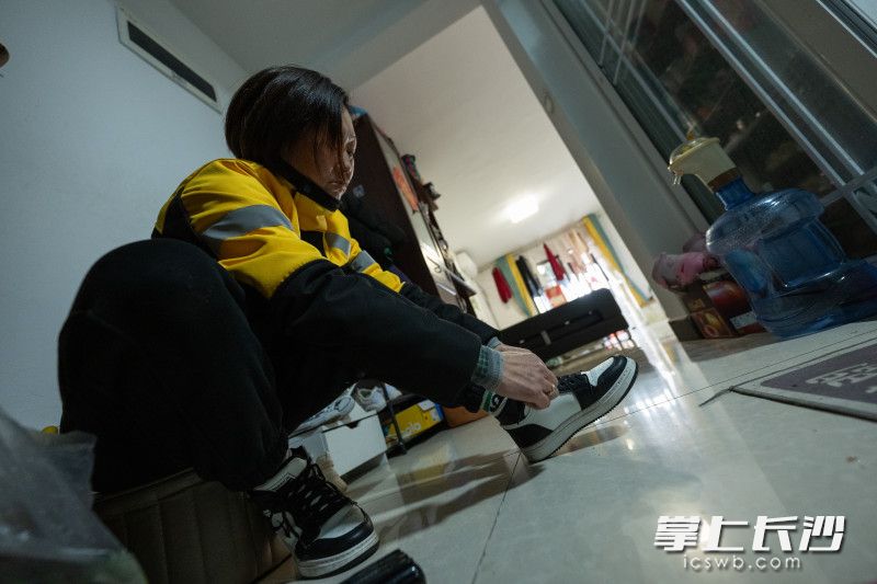 出门前李明珠穿起运动鞋，扎紧鞋带。