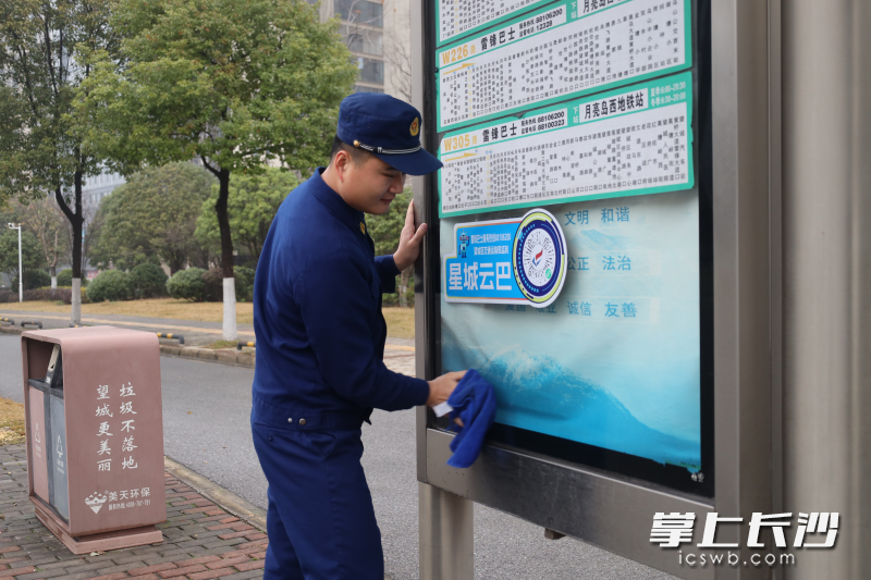 消防员在擦拭公交站牌。