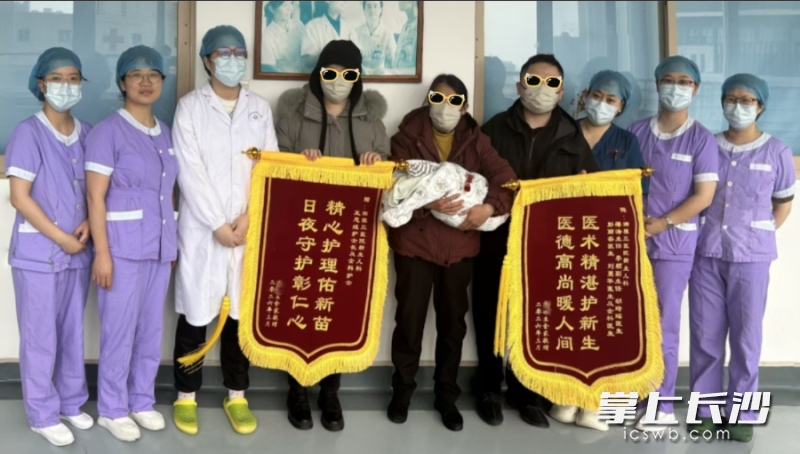 “小小”出院前，其家属为表达心中的感激之情，送来锦旗并与医护人员合影留念。