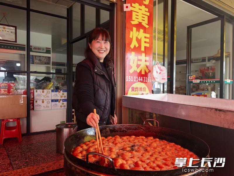 宁灰公路旁的黄炸作坊里,被食客们爱称为“黄炸妹”的陈利群，正在展示她的绝佳手艺。