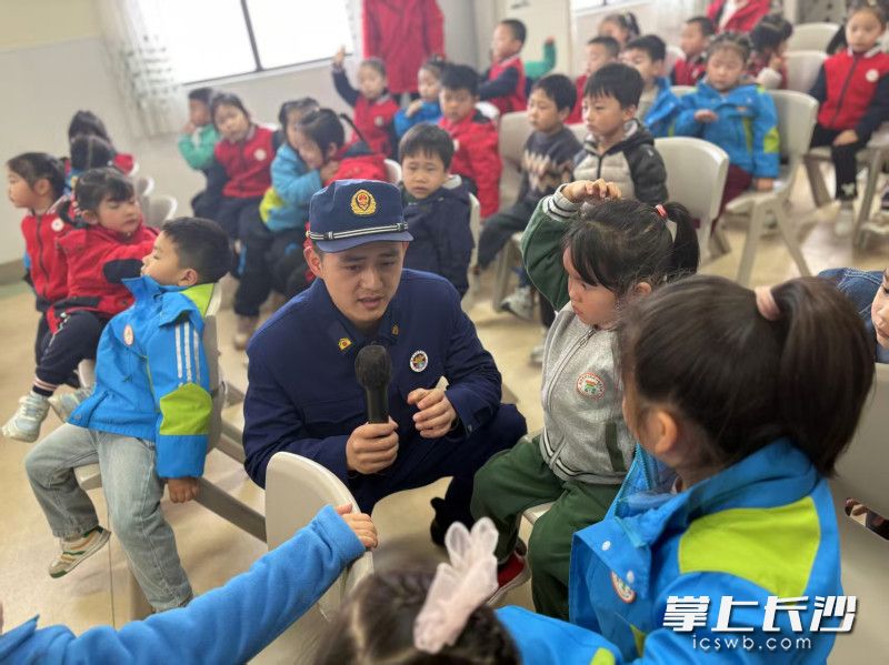 消防员与孩子们进行消防知识互动。