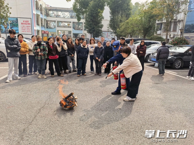 消防宣传员指导居民进行灭火实操。 长沙晚报通讯员 叶枫 摄