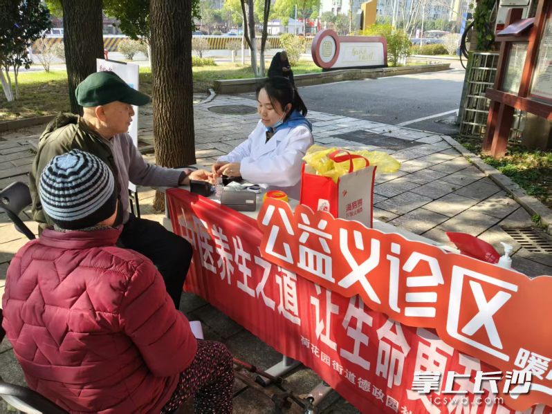 公益义诊区，医护人员正在给老人测量血压。