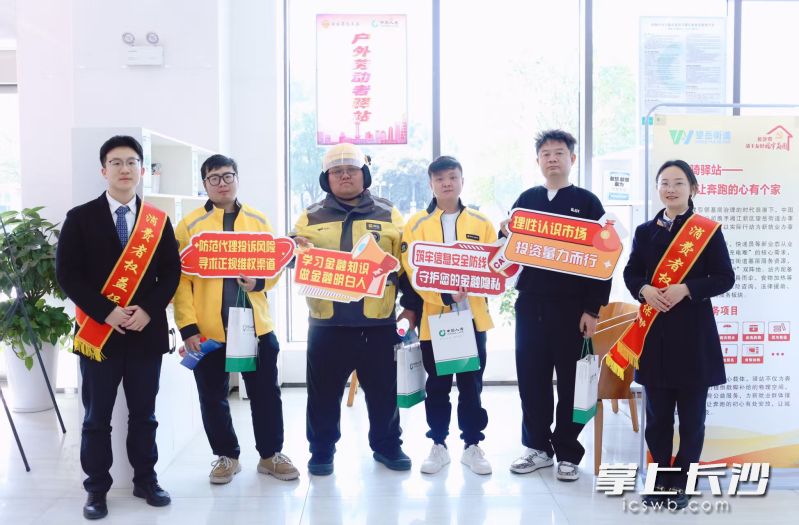 工作人员为骑手代表发放慰问品。