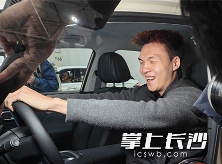 永州队队员谷文杰坐在新车上喜笑颜开。