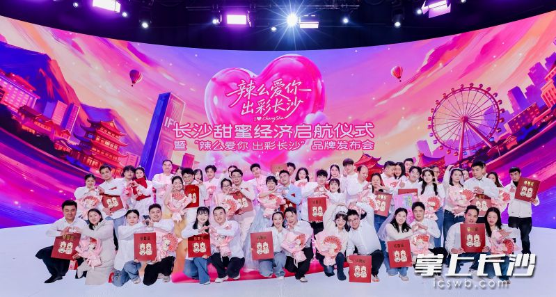 新婚青年代表领取“超大结婚证”和长沙派发的“甜蜜礼包”。