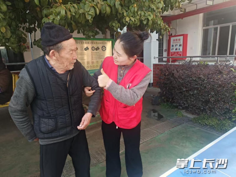 老人与社工交流康复训练后的身体健康状况，社工为老人的坚持点赞。