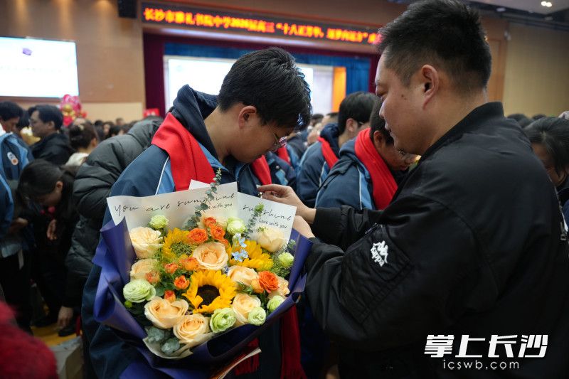 为孩子佩戴成长勋章，寄托着父母的殷殷嘱托。