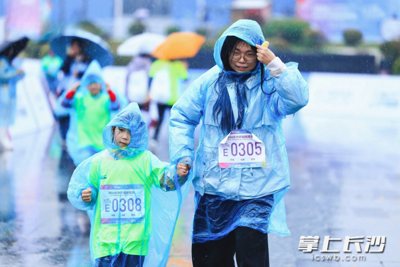 亲子冒雨奔跑不惧春寒。 亲子冒雨奔跑不惧春寒。