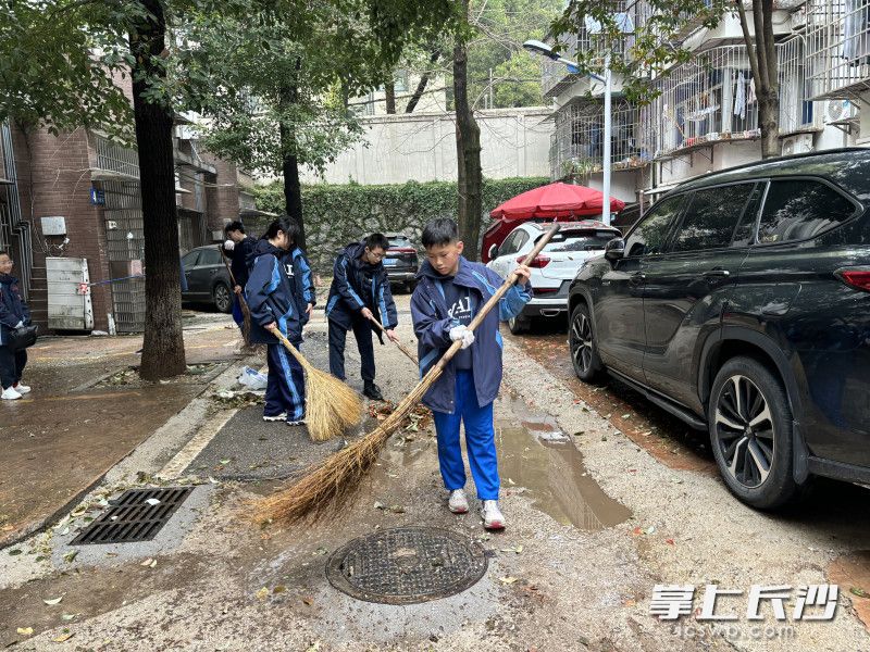 60余名学生分组包干，走进马家冲小区、雨花区政府宿舍等老旧小区，清理楼道堆物，铲除“牛皮癣”，捡拾绿化带垃圾。 均为长沙晚报通讯员李华摄