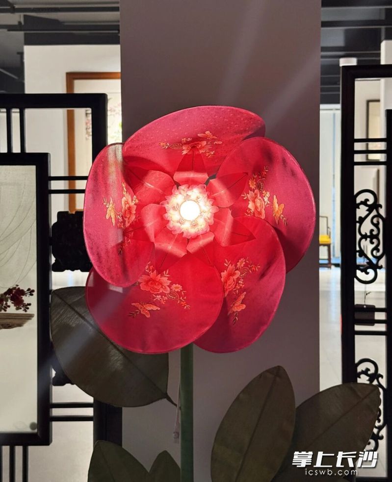 当人靠近,内置的智能感应装置被唤醒,绣面上的花瓣会如折扇般缓缓绽放,光影流转。 当人靠近,内置的智能感应装置被唤醒,绣面上的花瓣会如折扇般缓缓绽放,光影流转。