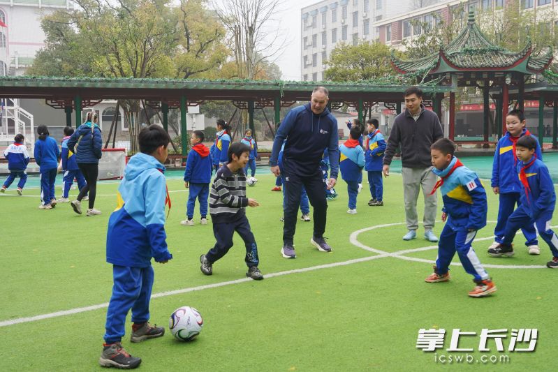 访问团成员与师大附小学生开展足球趣味互动。