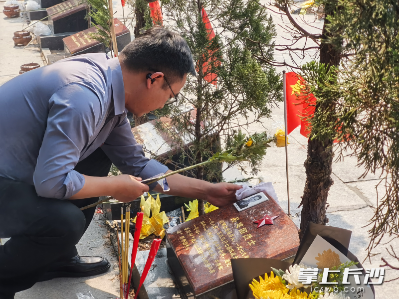 长沙市退役军人事务局党组成员、副局长邱献波为烈属进行代祭扫。
