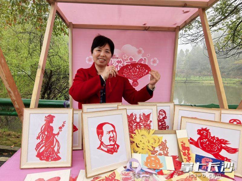 灰汤本土剪纸艺人张静自小与剪纸结缘，指尖翻飞间，一柄精巧的桃花纸扇便跃然眼前。