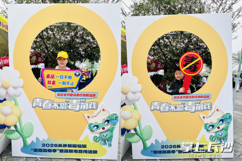 参与踏春登高的亲子家庭现场学习禁毒知识。